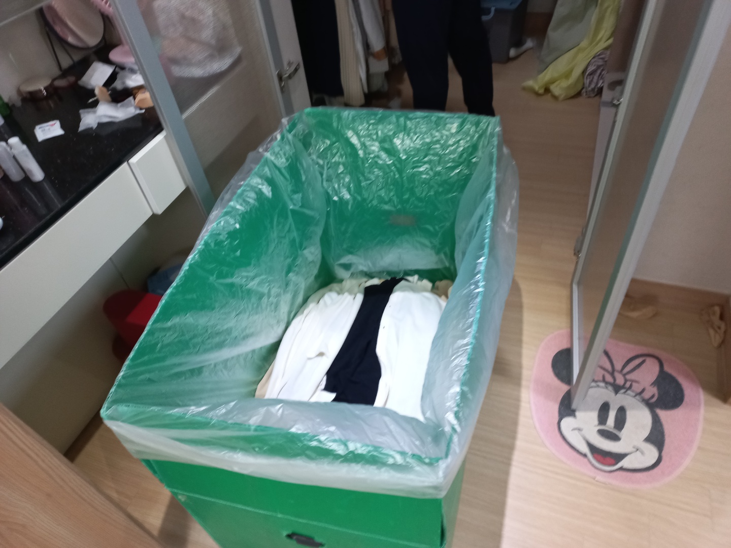 옷을 접힘 없이 담은 이사 바구니