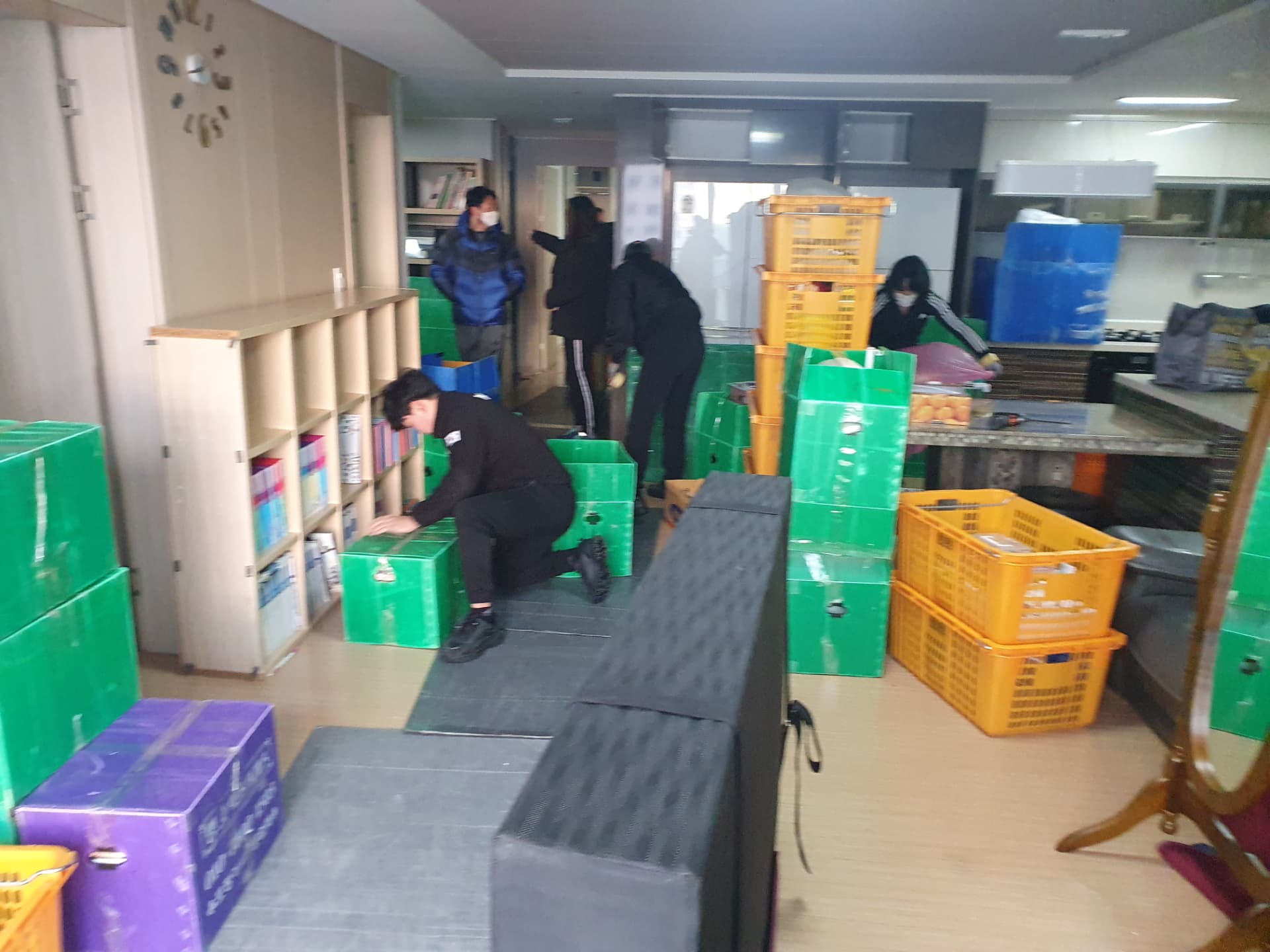 여러 작업자가 실내에서 짐을 포장하는 모습