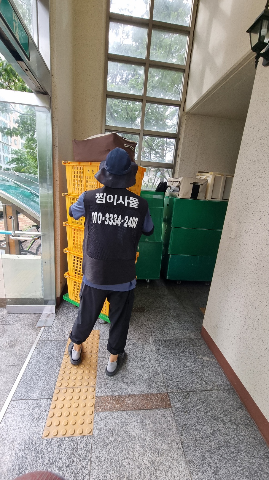 찜이사몰 유니폼을 착용한 작업자가 이사 바구니를 운반하는 모습